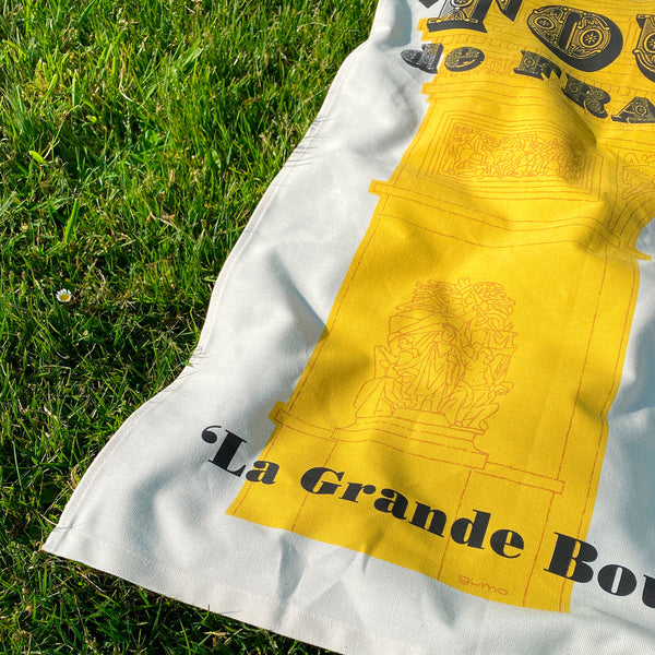 Cycling Grand Tour natural cotton tea towel, Tour de France bottom detail, on grass