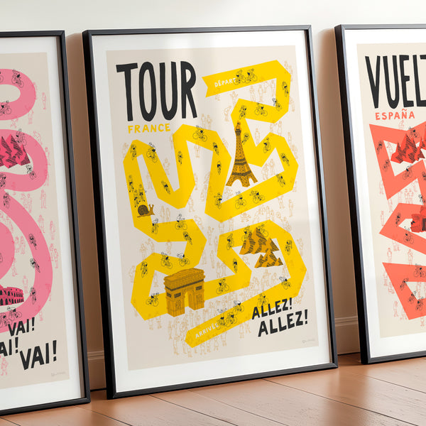 Three framed posters with cycling-themed designs on a wooden floor.