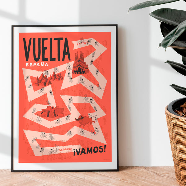 Framed poster with 'Vuelta Espana' design on a white wall with a plant.