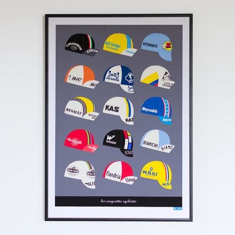 Vintage cycling caps print with a dark grey background, size A2, shown in a black frame.
