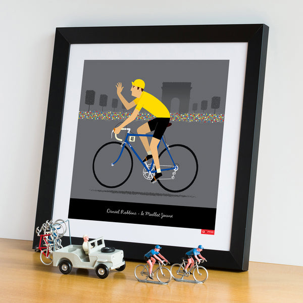 'Personalised Cycling Print, Yellow Jersey' with dark blue bike option. Size: 30 x 30 cm, shown in a black frame.